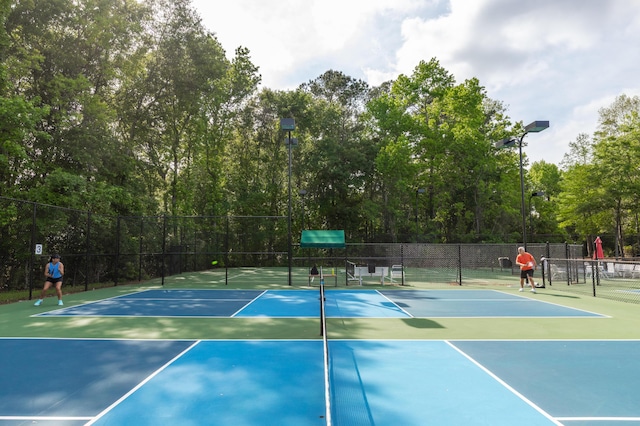view of tennis court featuring fence and community basketball court