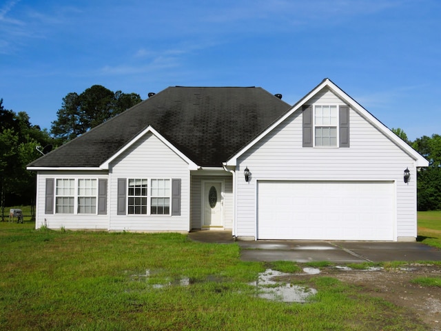 view of front facade with a front lawn, a shingled roof, and driveway