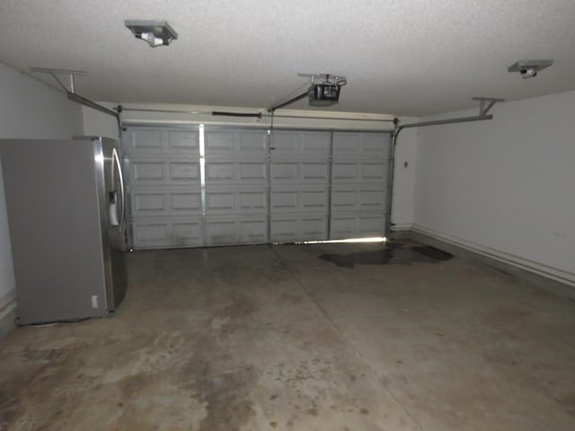 garage featuring stainless steel fridge and a garage door opener