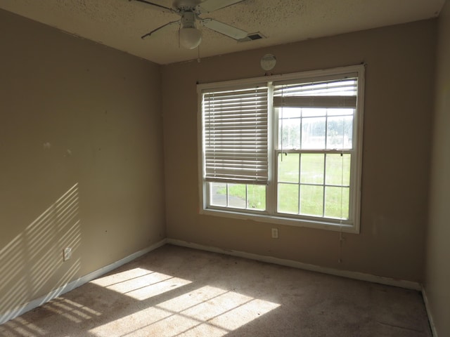 carpeted empty room featuring baseboards, a ceiling fan, and a textured ceiling