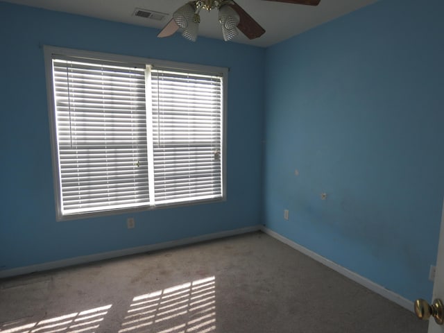 spare room with ceiling fan, carpet floors, and baseboards