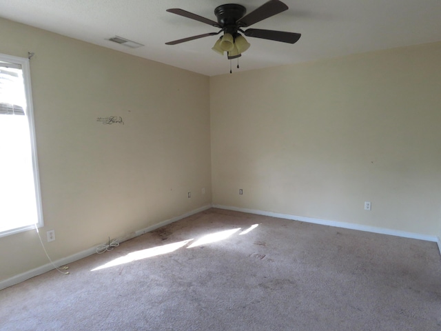 unfurnished room with plenty of natural light, carpet, a ceiling fan, and baseboards