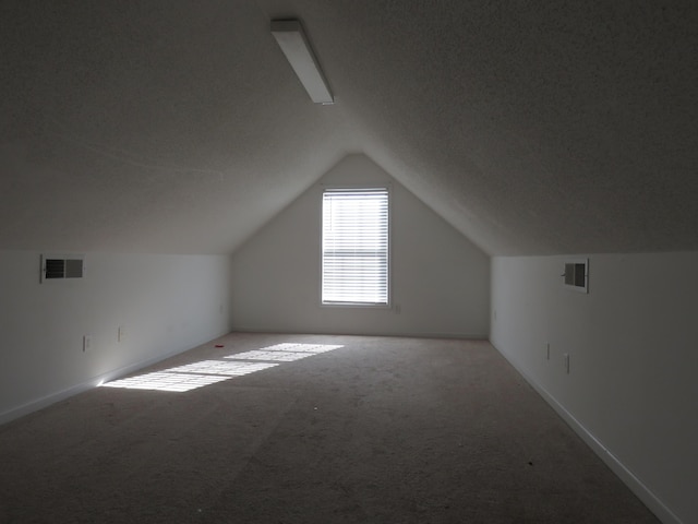 additional living space with carpet floors, vaulted ceiling, and baseboards