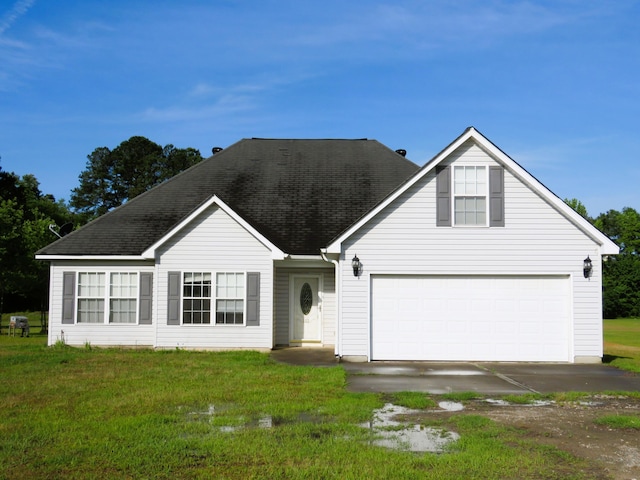 view of front of house featuring a front yard, a shingled roof, and driveway