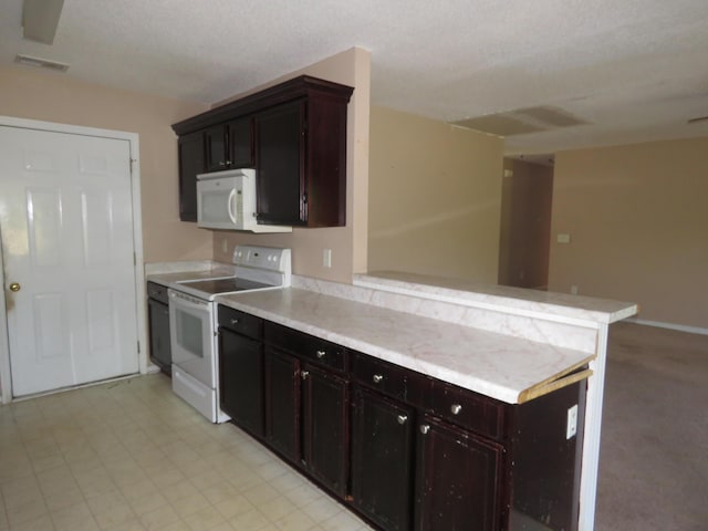 kitchen with white appliances, a peninsula, light countertops, dark brown cabinets, and open floor plan