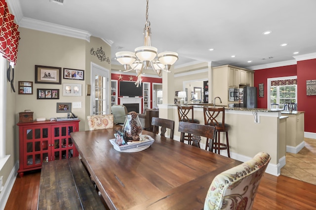 dining area featuring crown molding, baseboards, recessed lighting, and a chandelier