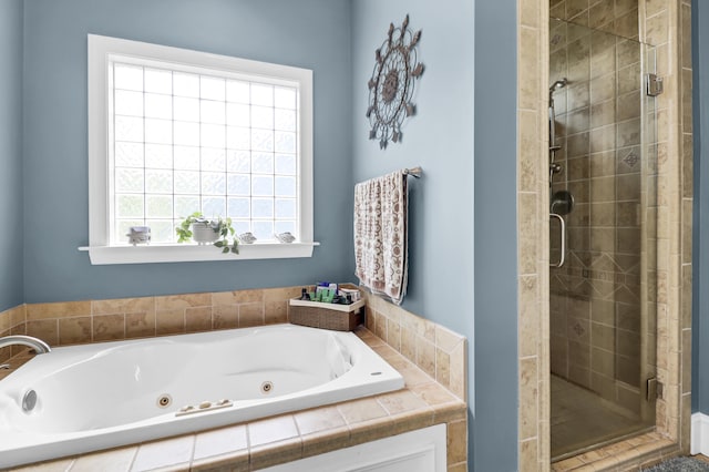bathroom with a shower stall and a jetted tub