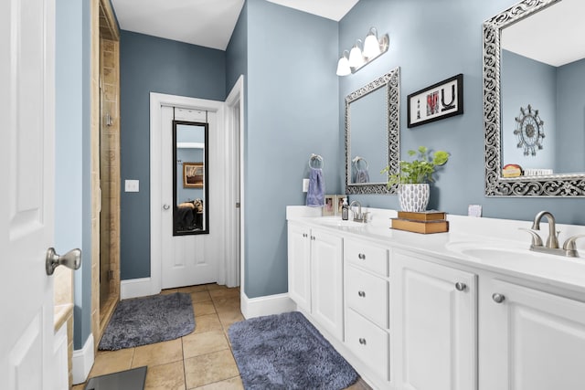 full bath with double vanity, a sink, baseboards, and tile patterned floors