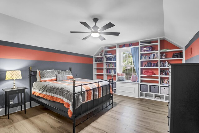 bedroom with ceiling fan, vaulted ceiling, and wood finished floors