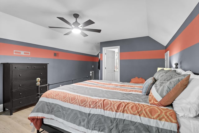 bedroom with ceiling fan, visible vents, light wood-style flooring, and lofted ceiling