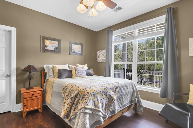 bedroom featuring baseboards, multiple windows, dark wood finished floors, and visible vents
