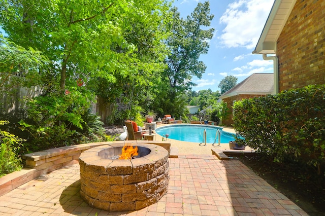 pool with a patio area and an outdoor fire pit