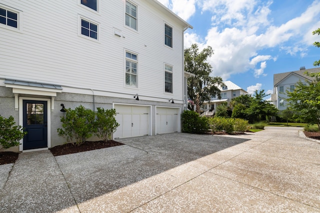566 Wading Pl, Daniel Island, SC 29492 - view of home's exterior featuring driveway, a garage, stucco siding, and a residential view