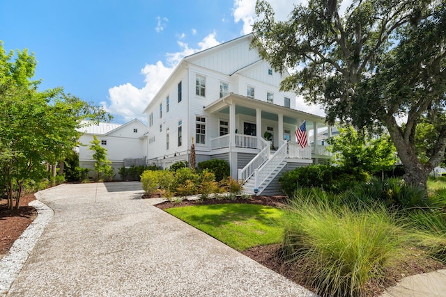 566 Wading Pl, Daniel Island, SC 29492 - view of front of home featuring covered porch, board and batten siding, and stairway
