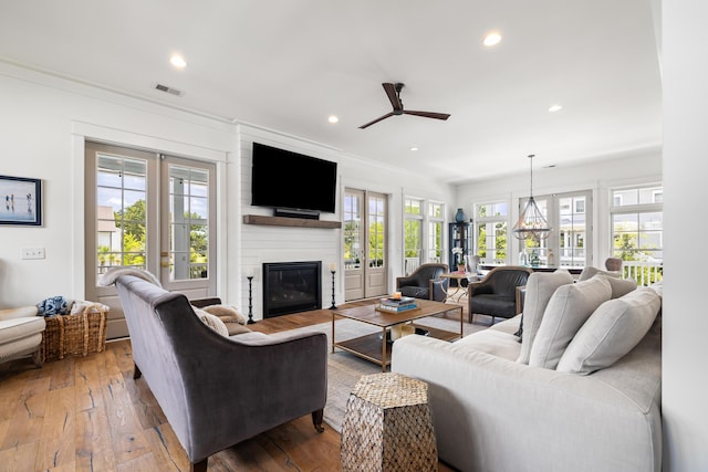 566 Wading Pl, Daniel Island, SC 29492 - living room featuring ceiling fan, a large fireplace, hardwood / wood-style floors, recessed lighting, and crown molding