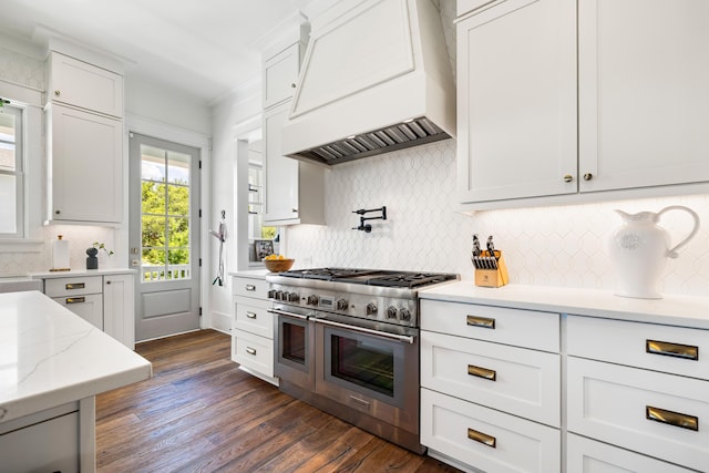 566 Wading Pl, Daniel Island, SC 29492 - kitchen with range with two ovens, custom exhaust hood, tasteful backsplash, and white cabinetry
