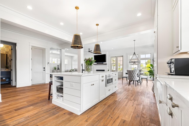 566 Wading Pl, Daniel Island, SC 29492 - kitchen featuring crown molding, light wood finished floors, white cabinetry, open shelves, and pendant lighting