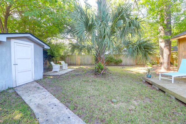 1159 Camden St, North Charleston, SC 29405 - view of yard with a fenced backyard, a wooden deck, an outdoor structure, and a shed