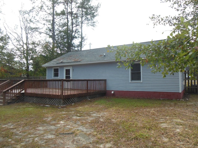 rear view of house with a wooden deck and a yard