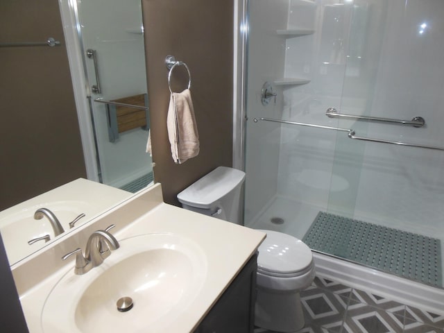 bathroom with a shower with door, toilet, and vanity