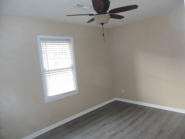 spare room with dark wood-type flooring and ceiling fan