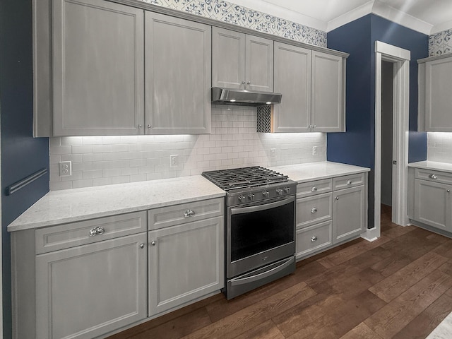 kitchen featuring stainless steel gas range oven, under cabinet range hood, dark wood-style floors, backsplash, and light stone counters