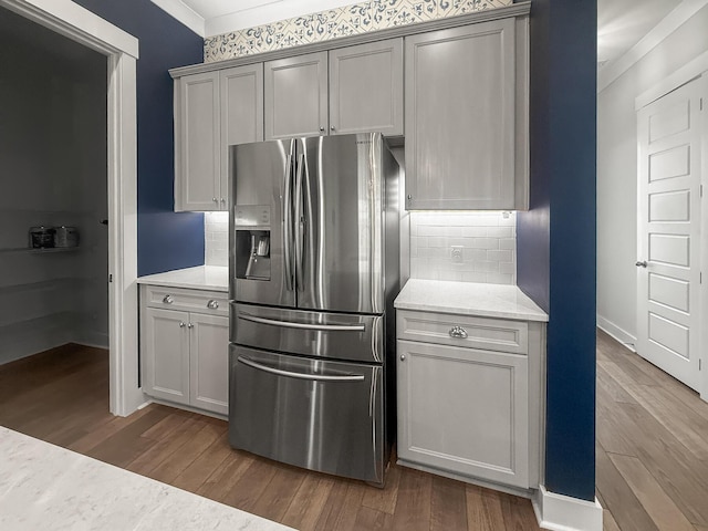 kitchen with stainless steel fridge, tasteful backsplash, dark wood-style floors, and ornamental molding
