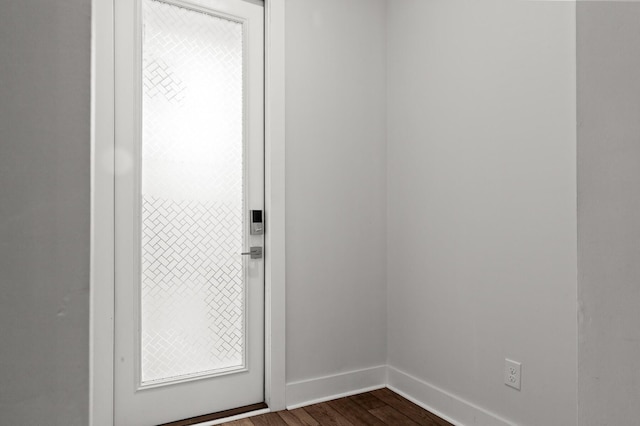 doorway with baseboards and dark wood finished floors