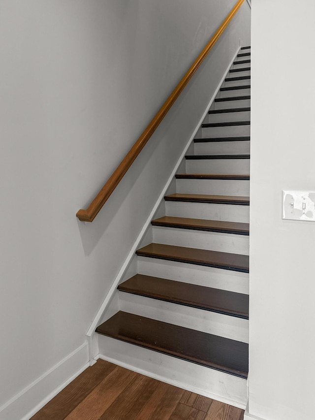 stairway with wood finished floors and baseboards