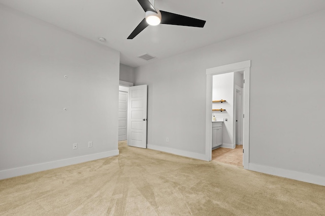 unfurnished bedroom with light carpet, baseboards, ensuite bathroom, and a ceiling fan
