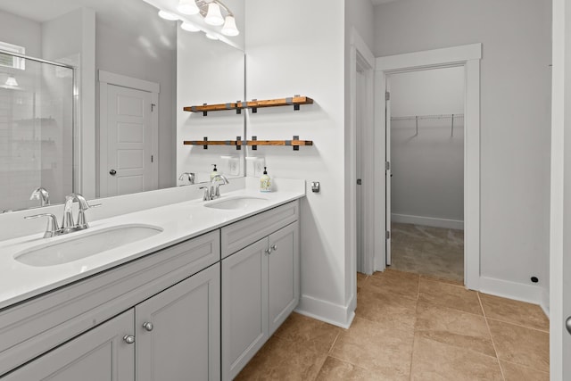 full bathroom featuring a shower stall, double vanity, baseboards, a spacious closet, and tile patterned flooring