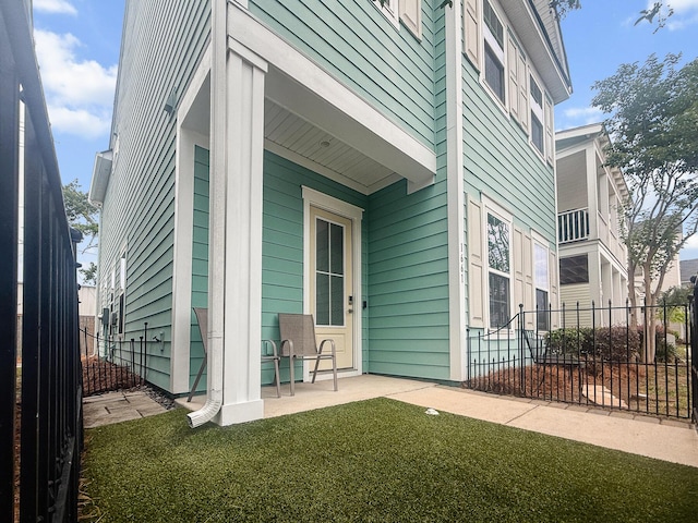 property entrance with fence and a patio