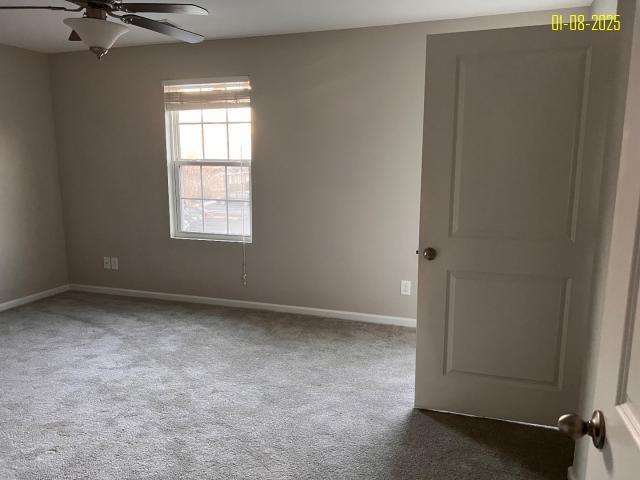 carpeted spare room with ceiling fan