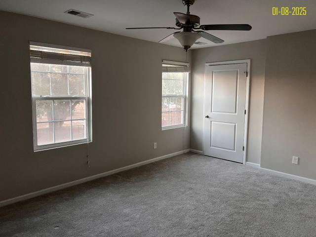 carpeted spare room with ceiling fan