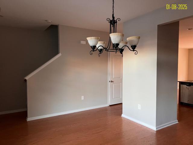 unfurnished dining area with a chandelier and dark hardwood / wood-style floors