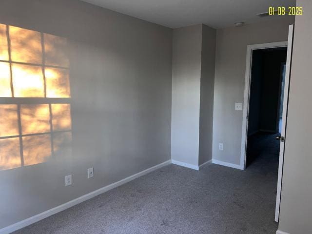 empty room with dark colored carpet