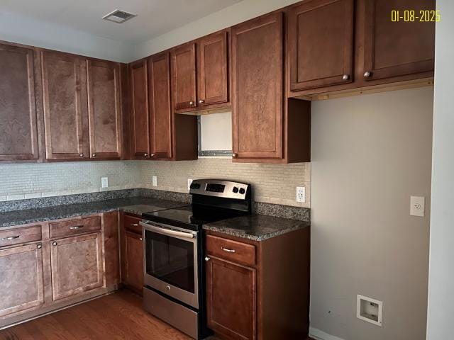 kitchen with backsplash, dark stone countertops, electric range, and dark wood-type flooring