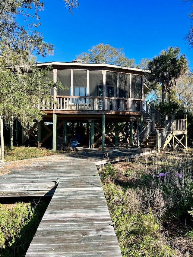 rear view of property with a deck and a sunroom