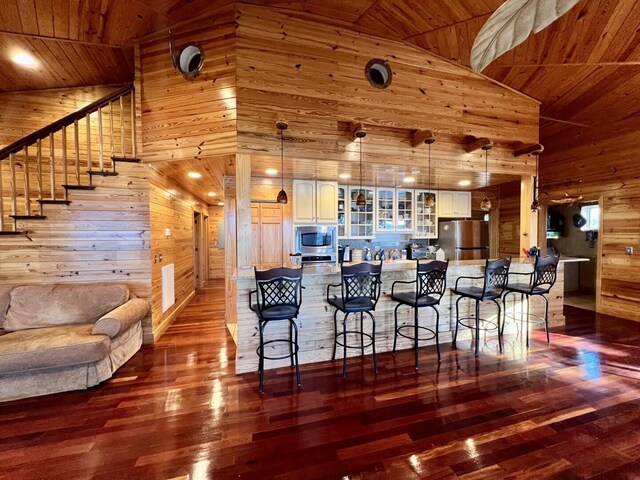 kitchen with high vaulted ceiling, hardwood / wood-style flooring, wooden ceiling, and stainless steel appliances