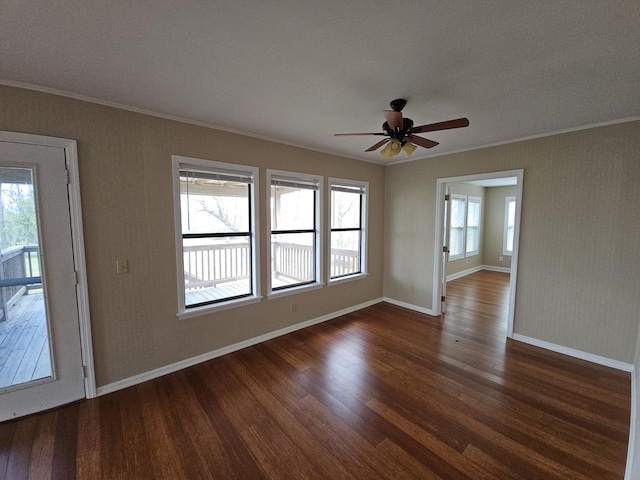 spare room with dark wood-style floors, ceiling fan, ornamental molding, and baseboards