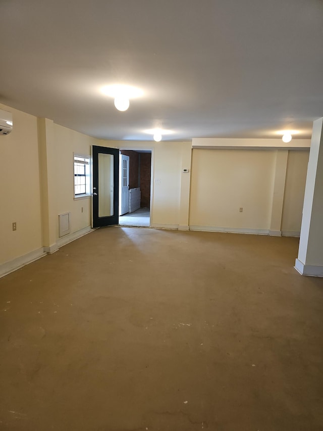 basement featuring a wall unit AC and baseboards