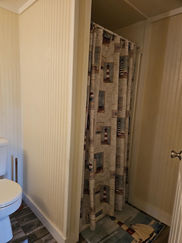 full bathroom featuring toilet and baseboards