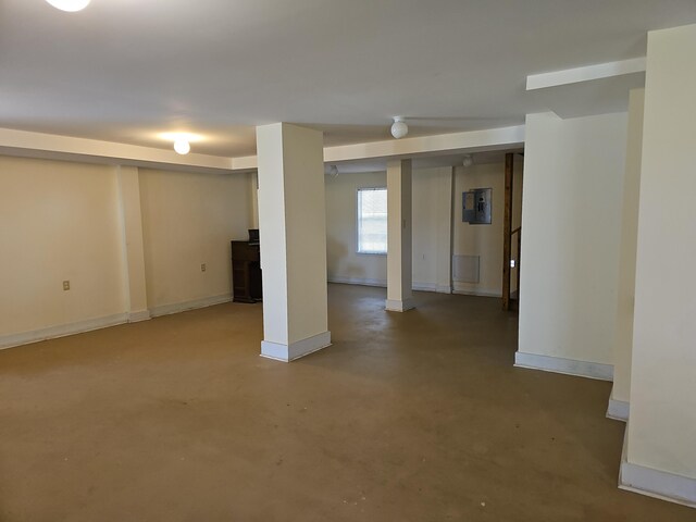 basement with electric panel and baseboards