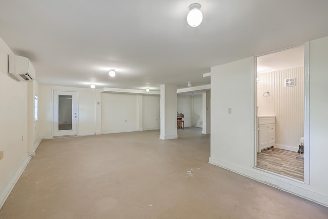 basement featuring baseboards and a wall mounted AC