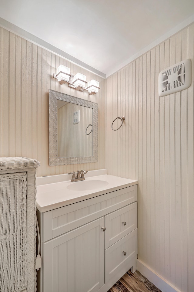 bathroom with wood finished floors, vanity, and baseboards