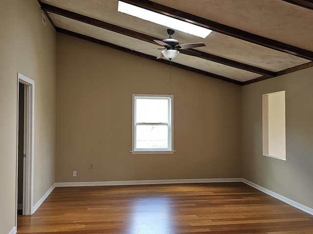 spare room featuring a ceiling fan, lofted ceiling with beams, baseboards, and wood finished floors