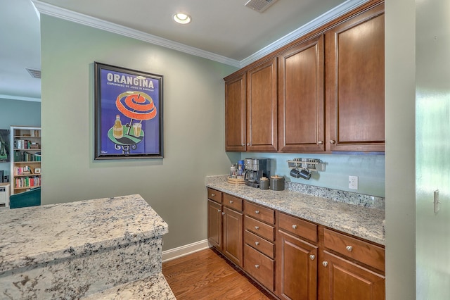 1408 Bimini Dr, Charleston, SC 29414 - kitchen featuring crown molding, light wood-style flooring, light stone counters, baseboards, and brown cabinetry