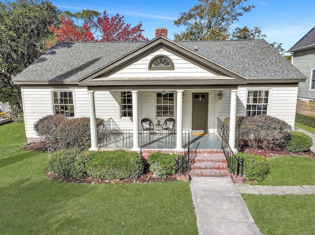 view of front of property featuring covered porch and a front lawn