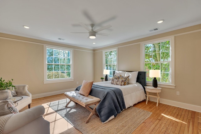 bedroom with ceiling fan, light wood-type flooring, crown molding, and multiple windows