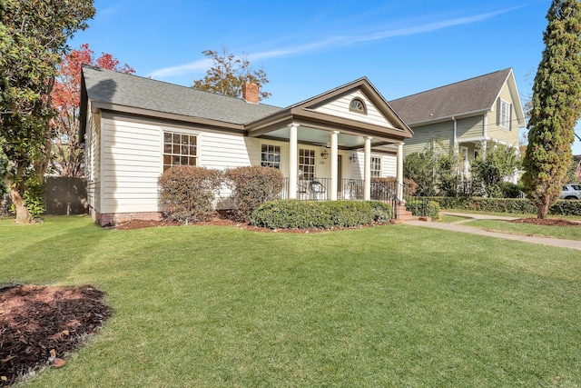 view of front of property with covered porch, ceiling fan, and a front yard